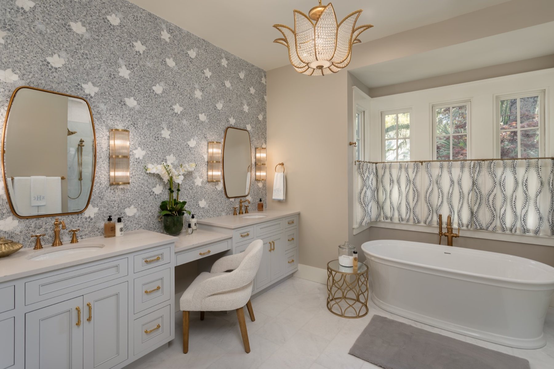 A primary bath with a freestanding tub and patterned wallpaper