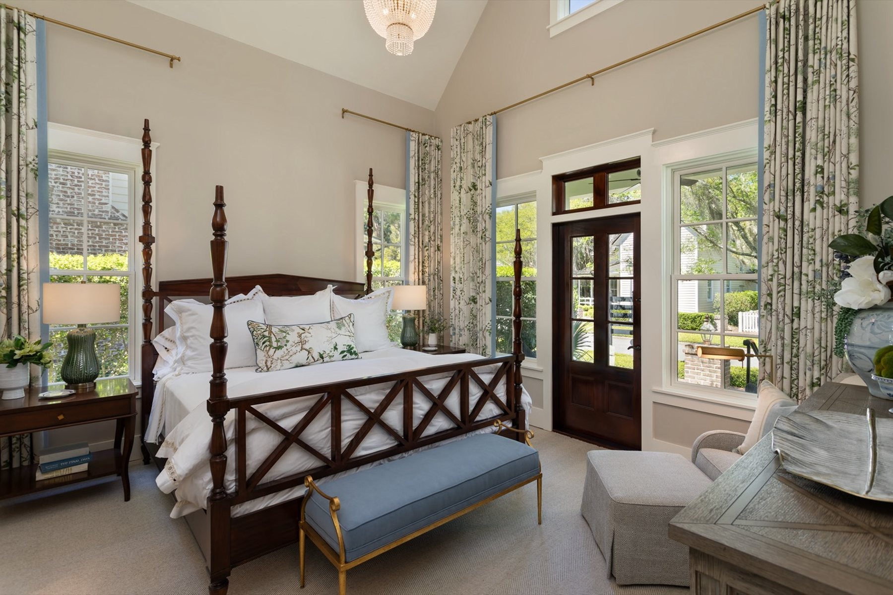 A bedroom with a four-poster bed and tall drapes