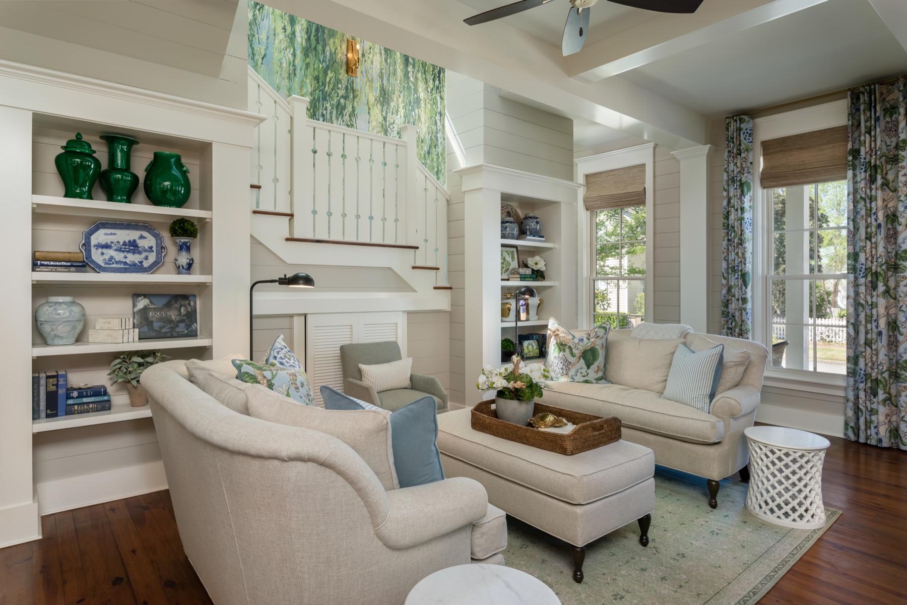 A family room with built-in shelves flanking the stair